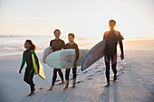 Family surfers carrying surfboards