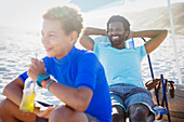 Father and son relaxing on sunny summer beach