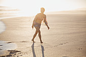 Smiling woman walking on sunny sandy summer beach