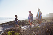 Family walking on sunny summer beach path