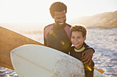 Portrait father and son surfers