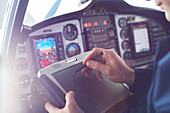 Airplane pilot using stylus on tablet in cockpit