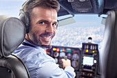 Portrait male pilot flying airplane in cockpit