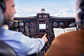 Pilots flying airplane in cockpit