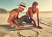 Young couple drawing in sand