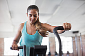 Focused woman using elliptical trainer