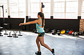 Young woman practicing lunges with kettlebell
