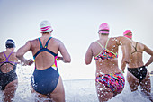 Female swimmers running and splashing