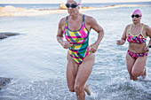 Determined female swimmers running