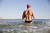 Female swimmer wading surf