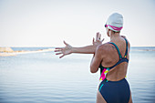 Female swimmer stretching arm and shoulder