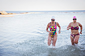 Female swimmers running and splashing