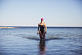 Portrait female swimmer wading, walking surf