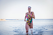 Portrait female swimmer running and splashing