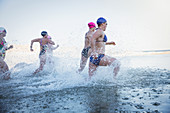 Female swimmers running and splashing