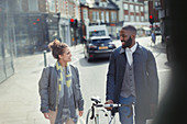 Couple walking, commuting with bicycle