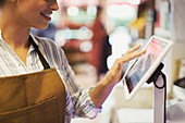 Female cashier using touch screen cash register