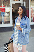 Smiling woman walking along storefront
