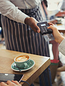 Customer paying waiter with credit card reader