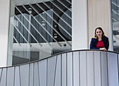 Businesswoman standing on modern office balcony