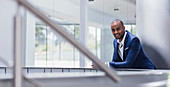 Portrait businessman leaning on railing in office