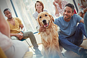 Man petting dog in group therapy session