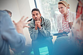 Attentive man and woman listening in group therapy