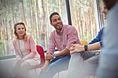 Smiling man listening in group therapy session