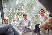 Smiling people talking in group therapy session