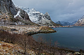 Snowy, rugged mountains along water, Norway