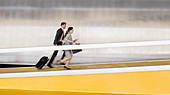Business people running up airport ramp