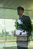 Pensive businessman looking out office window