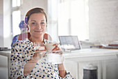 Portrait businesswoman drinking coffee in office