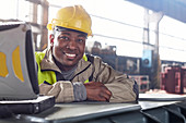 Portrait steelworker at laptop in steel mill