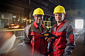 Portrait confident steelworkers with tablet