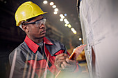 Focused steelworker at information board