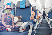 Girl fastening seat belt on stuffed animal