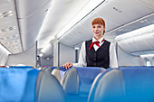 Portrait confident flight attendant on airplane