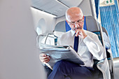 Businessman reading newspaper on airplane