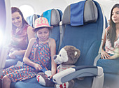Girl fastening seat belt on stuffed animal