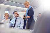 Smiling flight attendant adjusting pillow