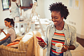 Woman drinking coffee and texting with smart phone