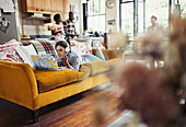 Young woman using laptop on living room sofa