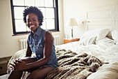 Portrait smiling, confident woman sitting on bed