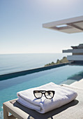 Sunglasses on folded towel at poolside