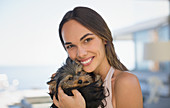 Smiling woman cuddling small dog