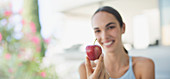 Smiling brunette woman holding red apple