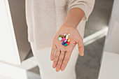 Woman holding multicoloured pills