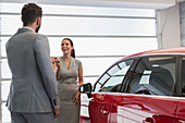 Car salesman giving keys to car to customer