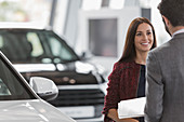 Smiling customer listening to car salesman